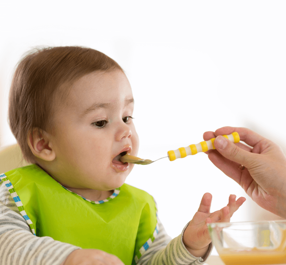 Bebé comiendo su papilla con una chuchara