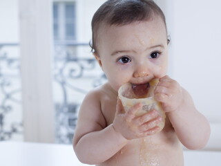 Bebé pequeño comiendo papilla de fruta.