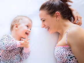 mamá-y-bebé-sonriendo-acostadas-en-la-cama