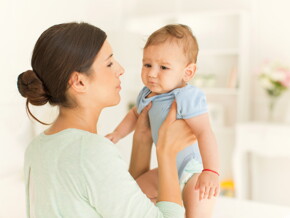 Mamá cargando a bebé con cólicos