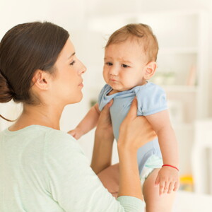 Mamá cargando a bebé con cólicos