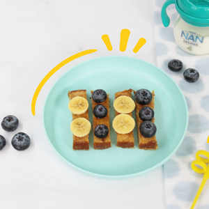 plato con pan francés con fruta y vaso entrenador con leche nan