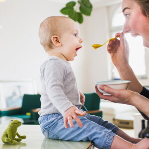 Mamá alimentando a su hijo con una papilla.