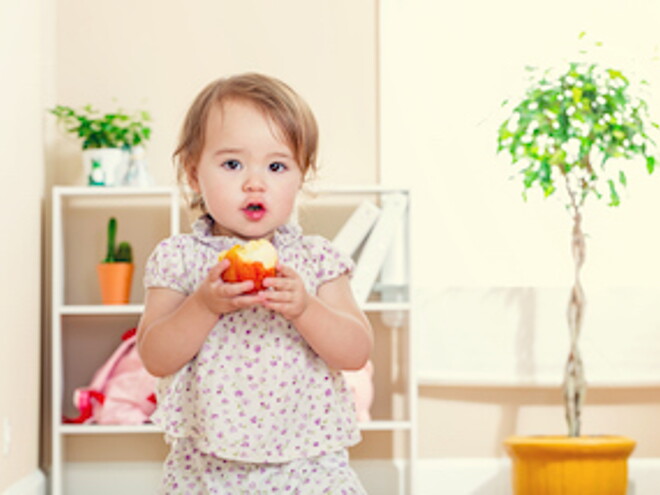 Niña pequeña comiendo manzana