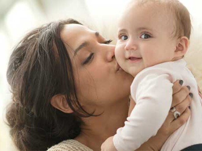 Madre besando a su bebe hidratado con Gerber