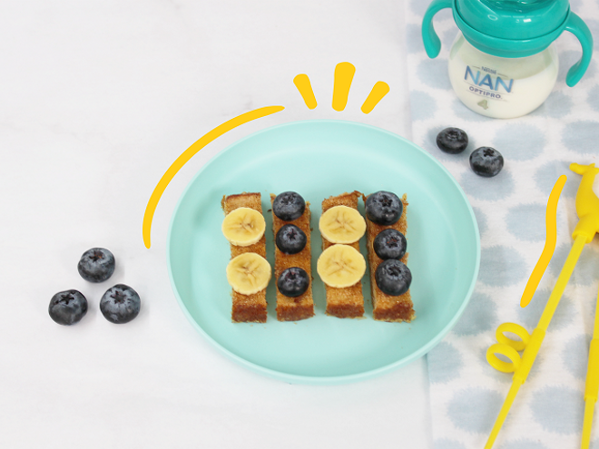 plato con pan francés con fruta y vaso entrenador con leche nan