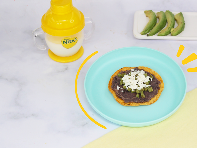 platos con tostadita mexicana y aguacate vaso entrenador con leche nido