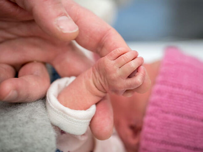 Mamá cogiendo la mano de su bebé de un mes