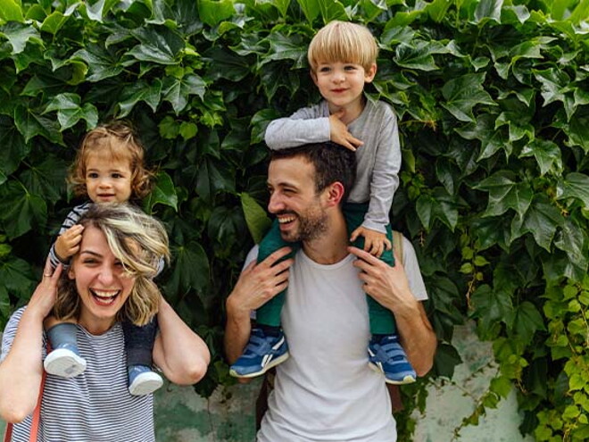 Los padres riendo con los hijos alzados