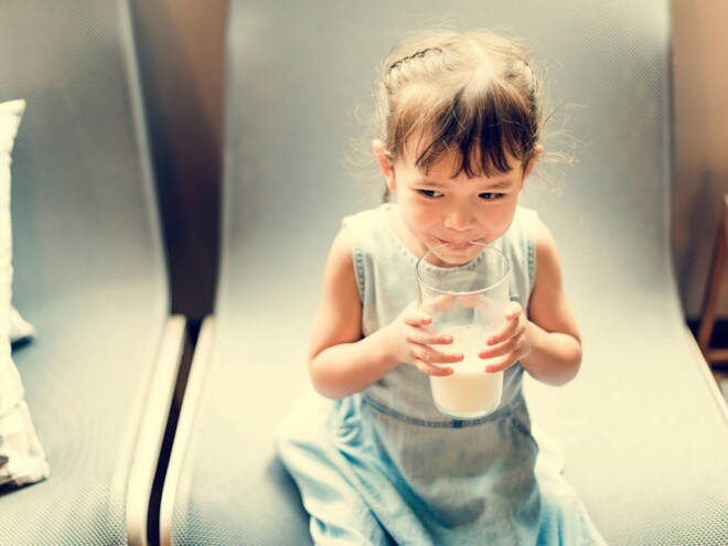 Niña tomando leche para tener defensas fuertes