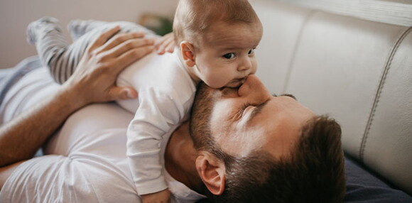 Papá cargando a su bebé de cuatro meses