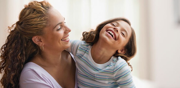 Mamá y niña sonriendo.