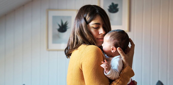 Mamá cargando a su bebé de un mes