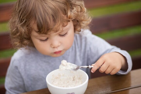 Bebé comiendo un alimento rico en proteinas