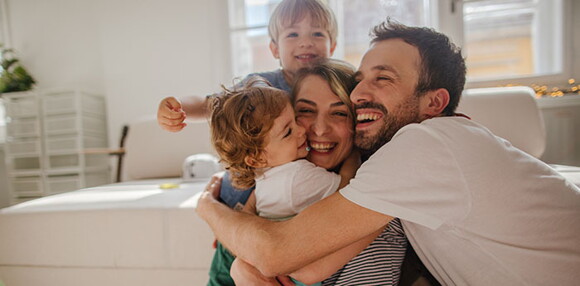 Papá y mamá abrazando a sus hijos