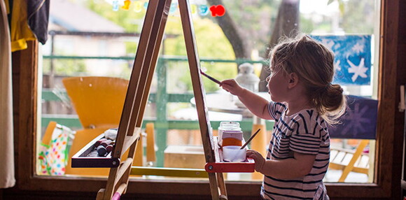 Niña pintando con pinturas como parte de su aprendizaje.