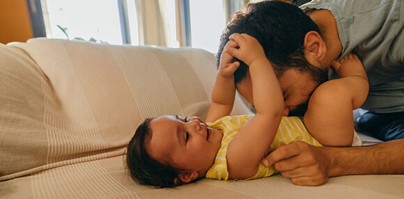 Papá jugando con su bebé de cinco meses