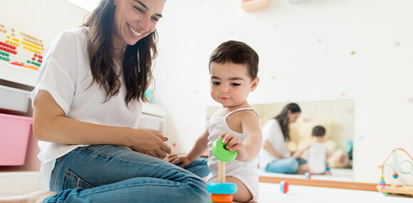 Mamá sentada con el bebé jugando