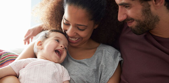 Bebé de cinco meses sonriendo con sus papás