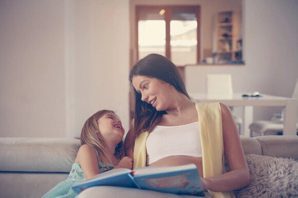 Mamá leyendo un cuento a su hija pequeña